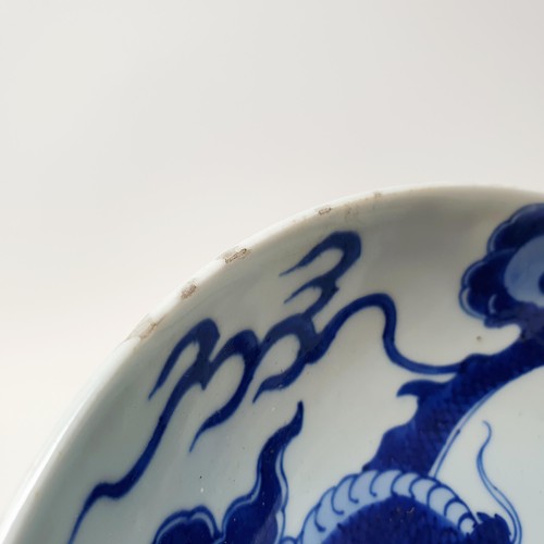 305 - A Chinese blue and white bowl, decorated dragon, six character mark to the base, 20 cm, and a shallo... 