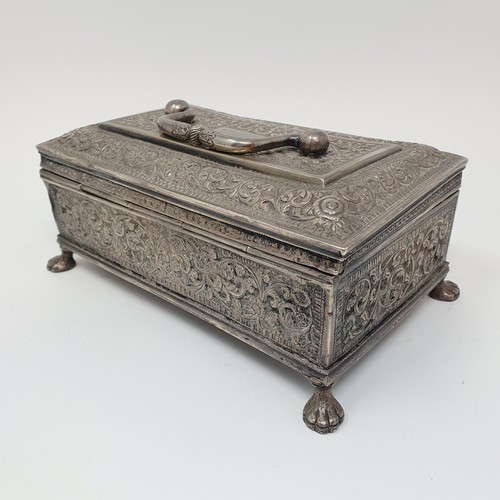 314 - An Eastern silver coloured metal casket, with a ring handle, on lion's paw feet, 18 cm wide