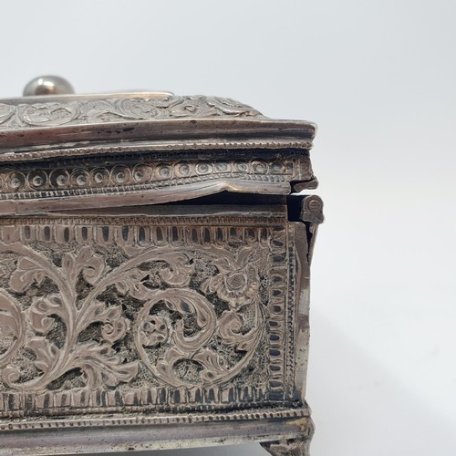 314 - An Eastern silver coloured metal casket, with a ring handle, on lion's paw feet, 18 cm wide