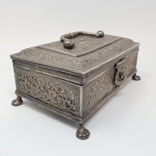 314 - An Eastern silver coloured metal casket, with a ring handle, on lion's paw feet, 18 cm wide