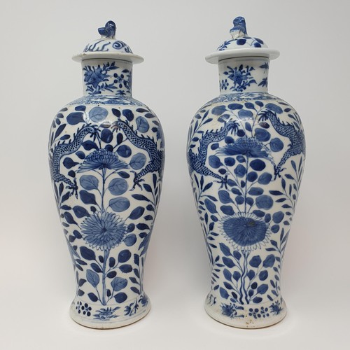 322 - A pair of Chinese underglazed blue and white vases, and covers, decorated dragons, four character ma... 