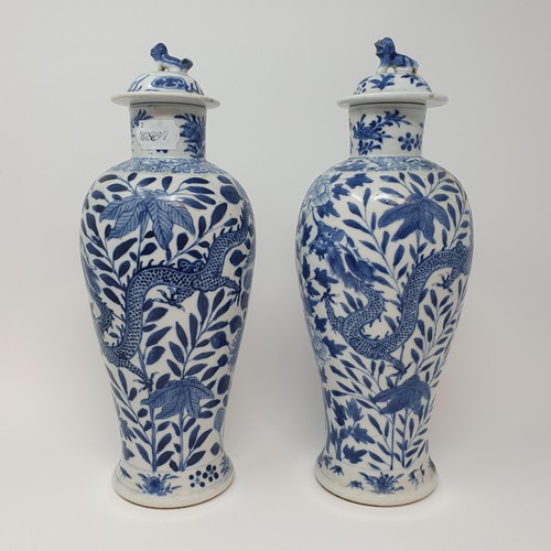 322 - A pair of Chinese underglazed blue and white vases, and covers, decorated dragons, four character ma... 