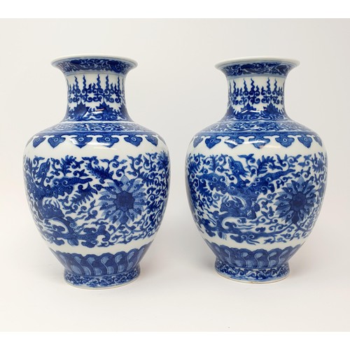 320 - A pair of Chinese underglazed blue and white vases, decorated mythical beasts and flowers, character... 