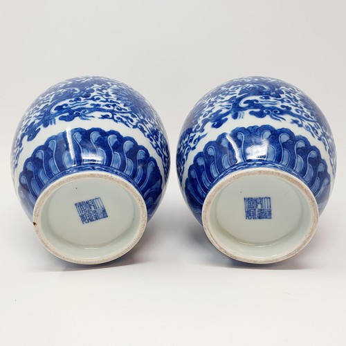 320 - A pair of Chinese underglazed blue and white vases, decorated mythical beasts and flowers, character... 