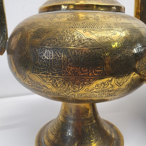 339 - An Islamic brass kettle, decorated script, 44 cm high, and a stand/burner, 38 cm diameter (2)