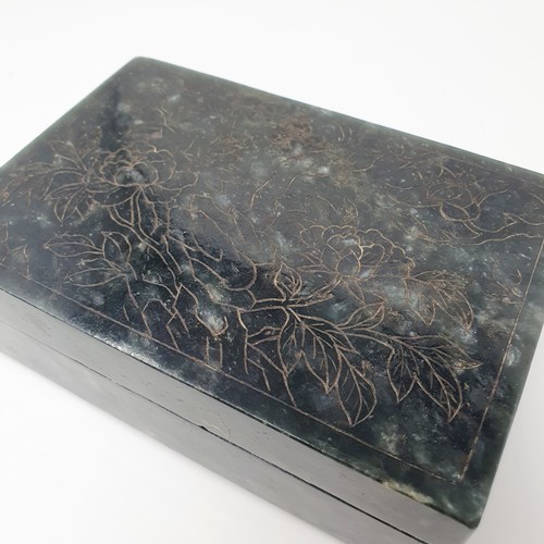 300 - A Chinese spinach-green jade box and cover, of rectangular form, the cover incised with a floral des... 