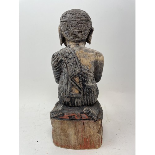 386 - An oriental figure of a praying man, 26 cm high, another similar, 27 cm high, and a carved stone fig... 