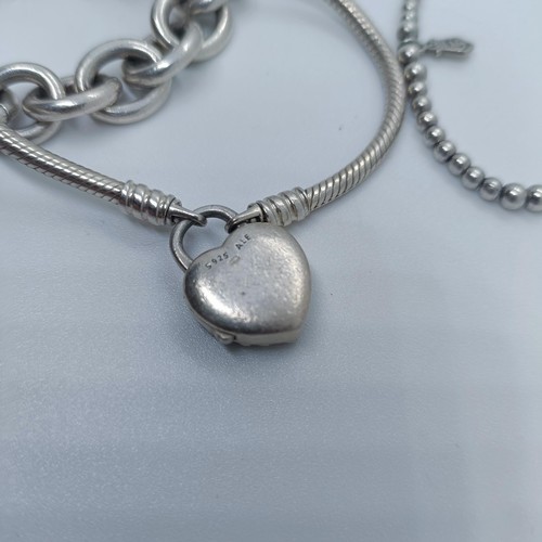 113 - A silver bracelet, with dog tags, and two other bracelets