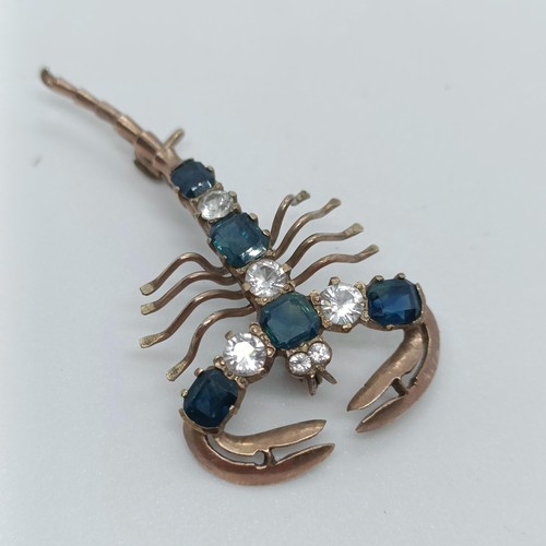 144 - A 9ct gold, blue and white stone scorpion brooch