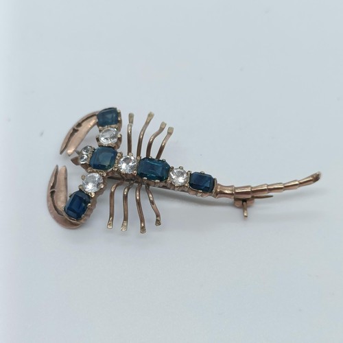 144 - A 9ct gold, blue and white stone scorpion brooch