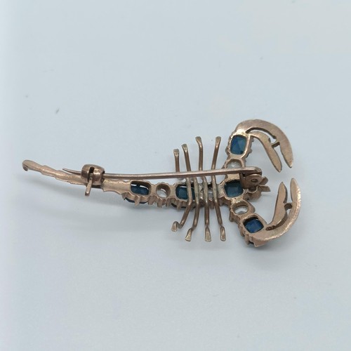 144 - A 9ct gold, blue and white stone scorpion brooch