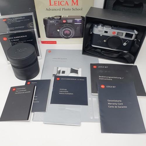 8 - A Leica M camera, boxed, a lens, boxed, a Leica M manual, tripod, and associated paperwork