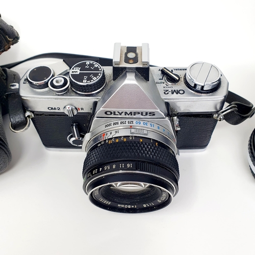 62 - An Olympus OM-2 camera, and two lenses