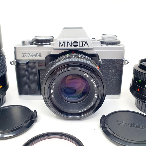 73 - A Minolta XG-M camera, two lenses, a slide projector, and other items (box)