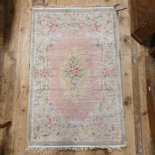 941 - A Chinese pink ground silk rug, 124 x 180 cm