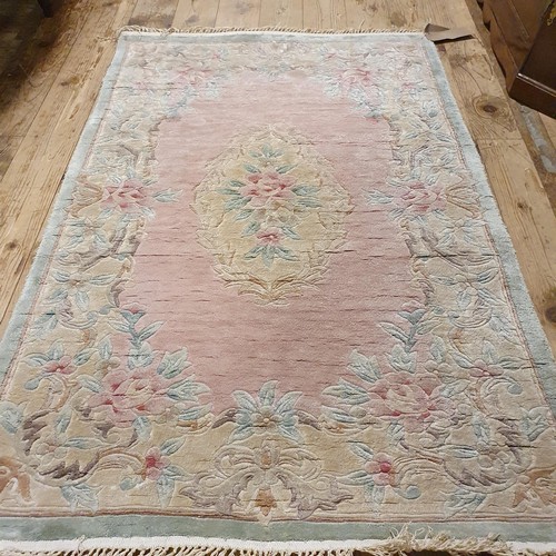 941 - A Chinese pink ground silk rug, 124 x 180 cm