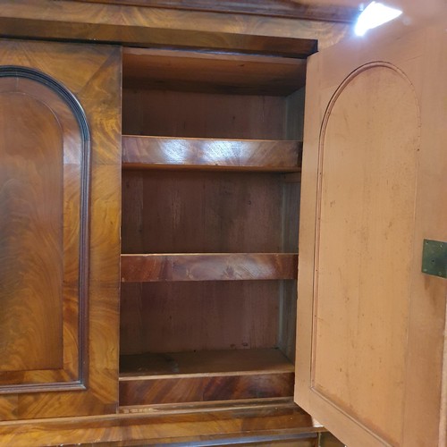 853 - A 19th century mahogany linen press, the top having two cupboard doors, on a base with three drawers... 