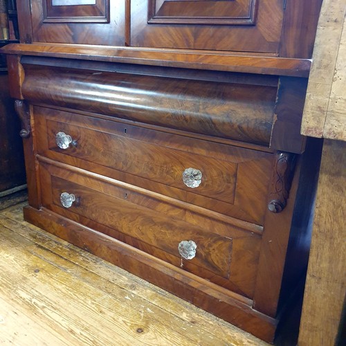 853 - A 19th century mahogany linen press, the top having two cupboard doors, on a base with three drawers... 