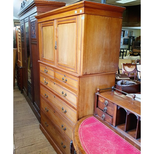 855 - A Heal's & Co walnut linen press, the top having two cupboard doors, on a base with two short and th... 