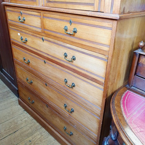 855 - A Heal's & Co walnut linen press, the top having two cupboard doors, on a base with two short and th... 