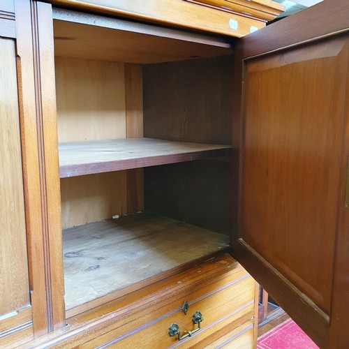 855 - A Heal's & Co walnut linen press, the top having two cupboard doors, on a base with two short and th... 