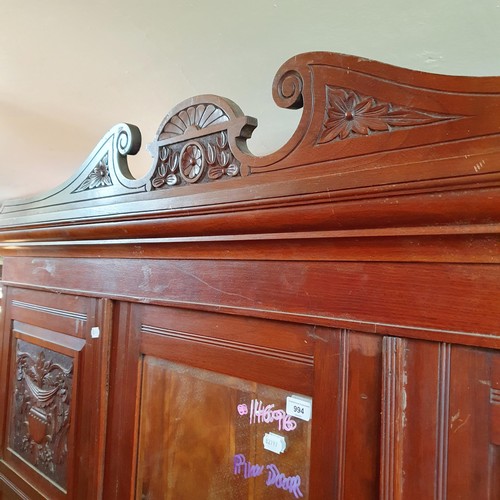 875 - An early 20th century walnut triple wardrobe, with a central mirrored door, 185 cm wide