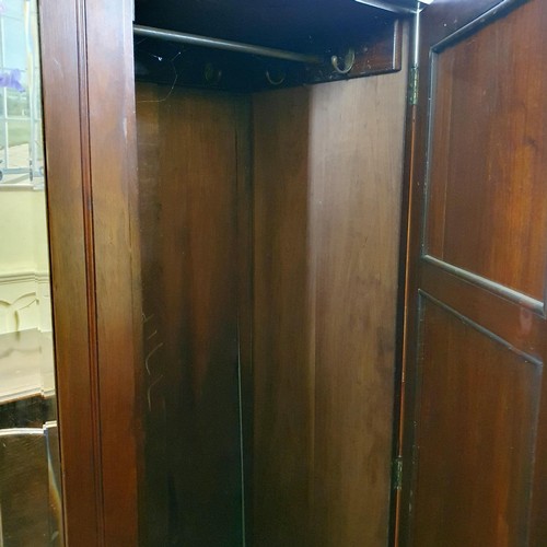 875 - An early 20th century walnut triple wardrobe, with a central mirrored door, 185 cm wide