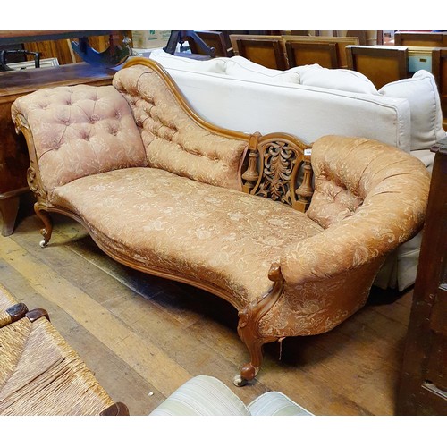 903 - A 19th century walnut framed button back chaise longue, with a carved pierced back, on cabriole legs... 