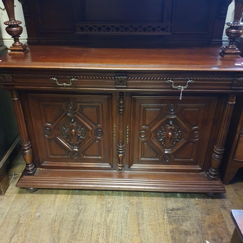 930 - A 19th century Continental walnut sideboard, the superstructure with a carved panel door, decorated ... 