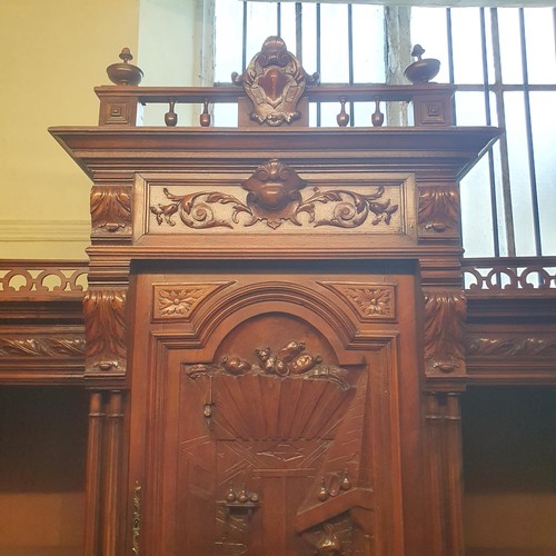 930 - A 19th century Continental walnut sideboard, the superstructure with a carved panel door, decorated ... 