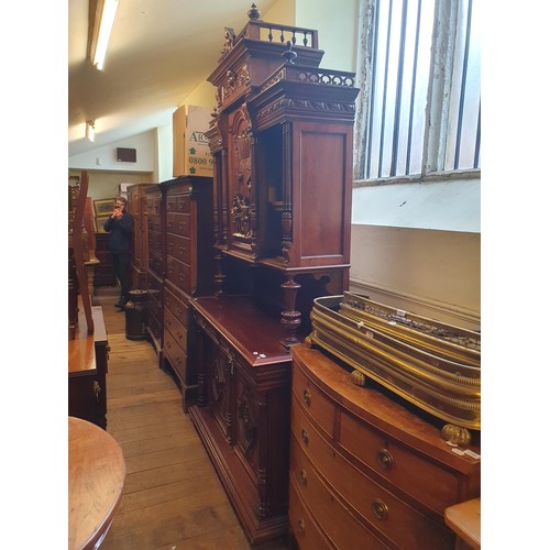 930 - A 19th century Continental walnut sideboard, the superstructure with a carved panel door, decorated ... 