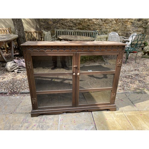 1048 - A carved oak bookcase, having a pair of glazed doors, 118 cm wide