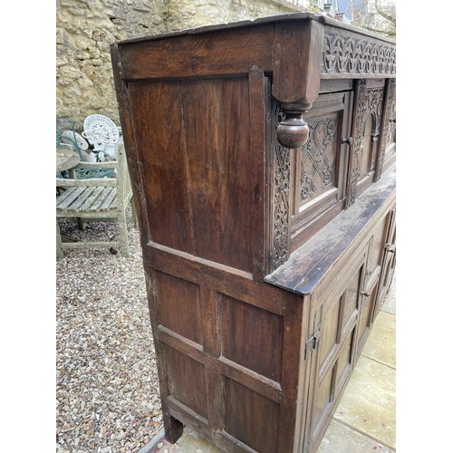 1006 - An 18th century carved oak court cupboard, the top with two cupboard doors, and the base with two cu... 