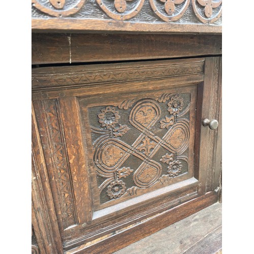 1006 - An 18th century carved oak court cupboard, the top with two cupboard doors, and the base with two cu... 