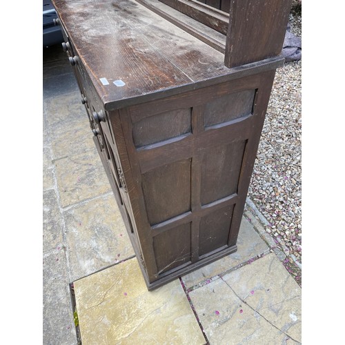 1004 - An oak dresser, with a three tier plate rack, on a base with two drawers and two cupboard doors, car... 