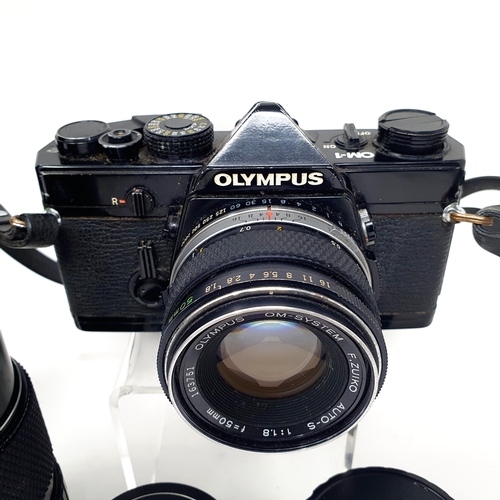 95 - An Olympus OM-1 camera, a Vivitar telephoto lens, and other lenses in an aluminium carrying case