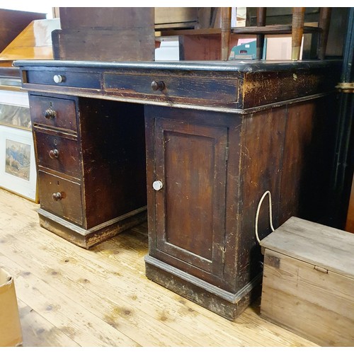 877 - An early 20th century stained pine pedestal desk, the top with two drawers, on pedestals with four d... 