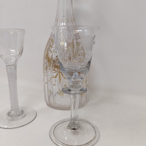 700A - A double cotton twist glass, another similar and a decanter and stopper with gilt decoration in the ... 