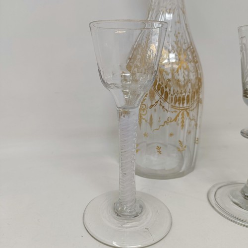 700A - A double cotton twist glass, another similar and a decanter and stopper with gilt decoration in the ... 