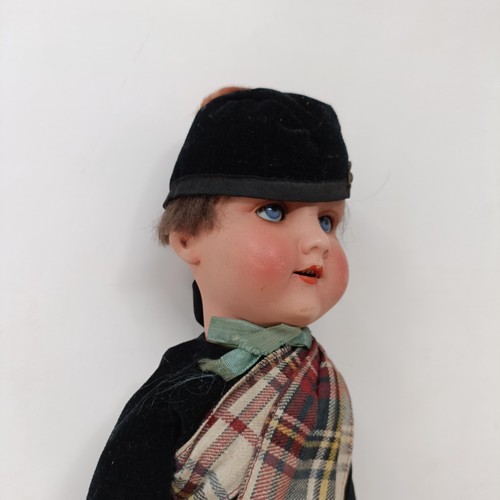 210 - An Armand Marseille bisque headed doll, No. 390, in a Scottish costume with bagpipe