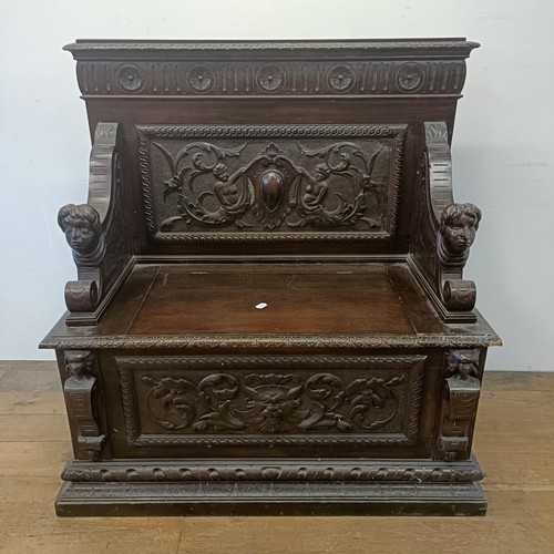 872 - A late Victorian carved oak box settle, 110 cm wide