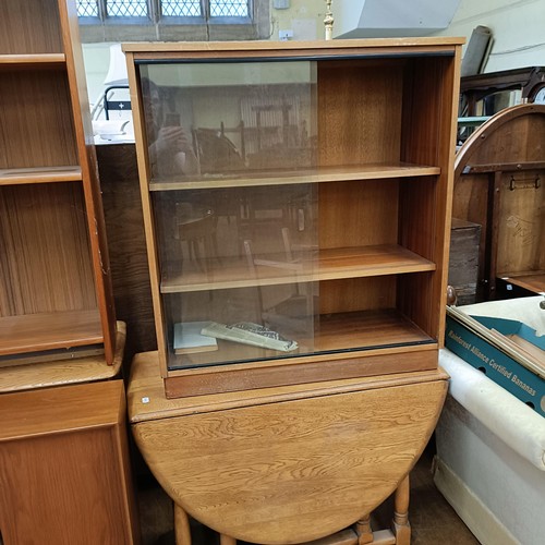 990 - An oak sideboard, 120 cm wide, a teak bookcase, two glazed bookcases, an oak drop leaf table, four c... 