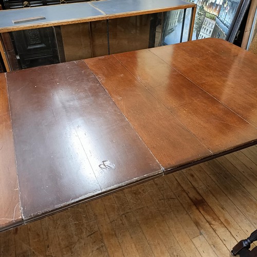 1017 - An early 20th century oak extending dining table, with two extra leaves, the top 124 cm wide