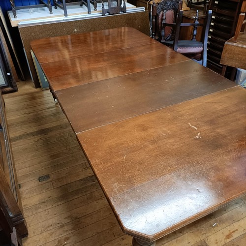 1017 - An early 20th century oak extending dining table, with two extra leaves, the top 124 cm wide