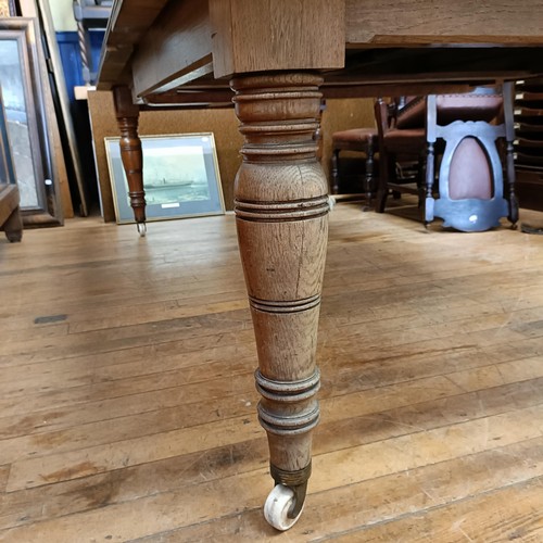 1017 - An early 20th century oak extending dining table, with two extra leaves, the top 124 cm wide