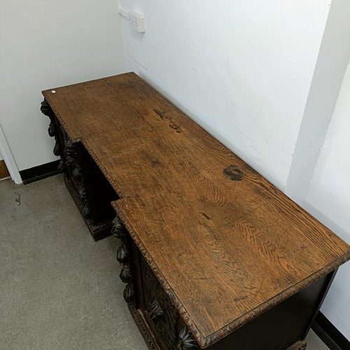 1034 - A carved oak sideboard, 187 cm wide