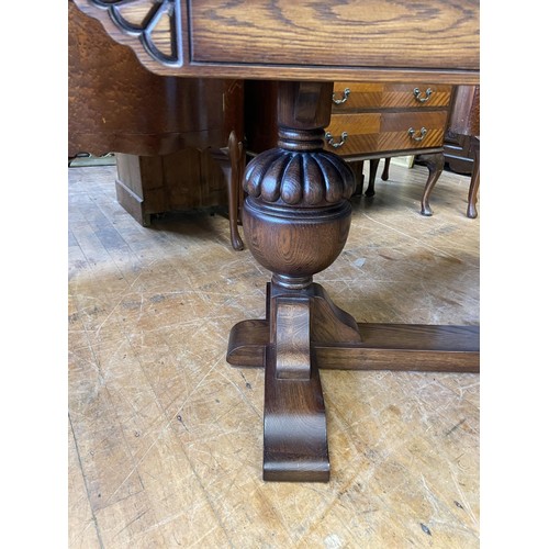 986 - An oak draw leaf dining table, on carved bulbous supports, united by a stretcher, the top 92 x 180 c... 