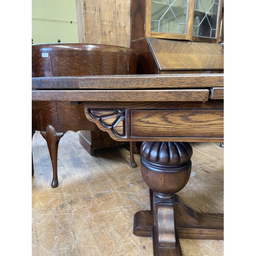 986 - An oak draw leaf dining table, on carved bulbous supports, united by a stretcher, the top 92 x 180 c... 