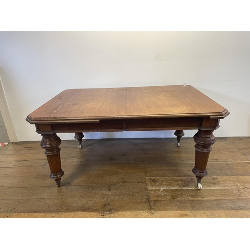 969 - A mahogany extending dining table, the top 155 cm x 105 cm, with two extra leaves,