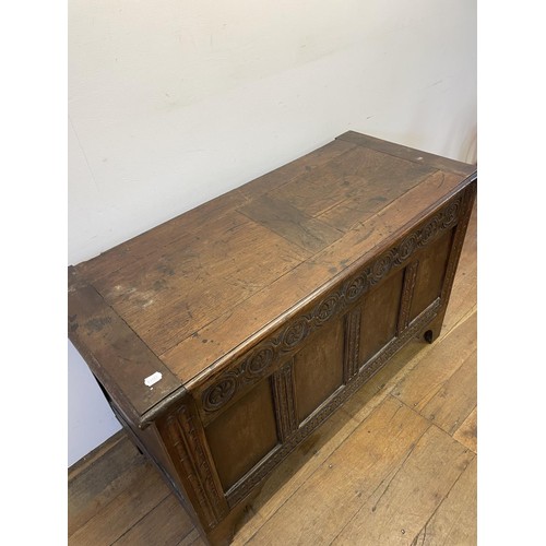 869 - An 18th century carved oak coffer, 122 cm wide